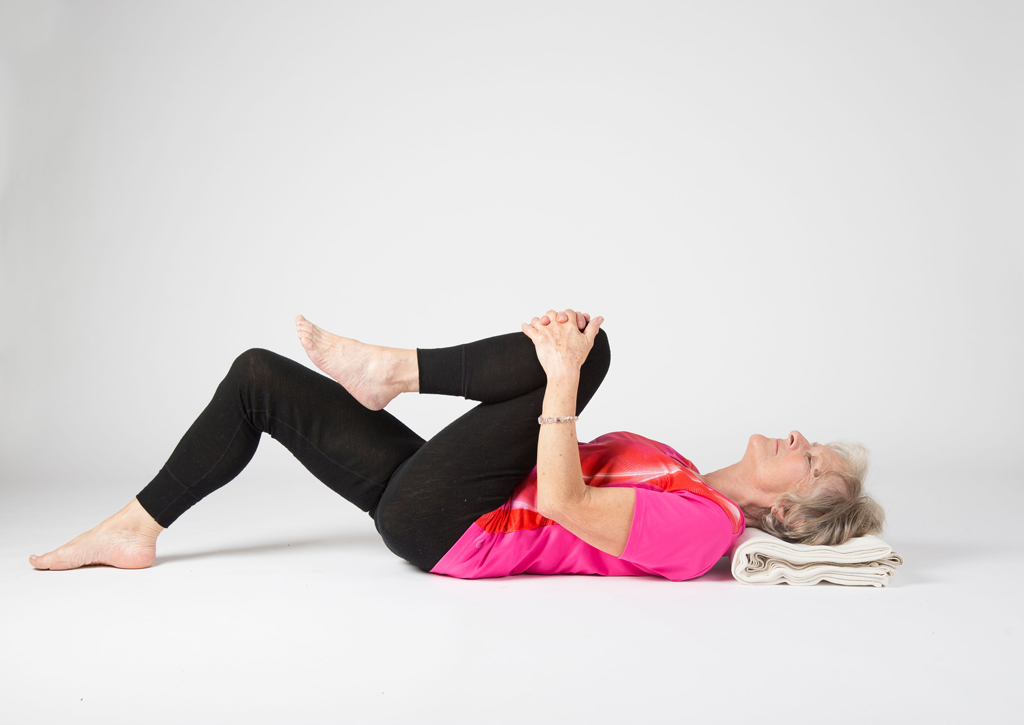Yoga student in lying knee to chest pose