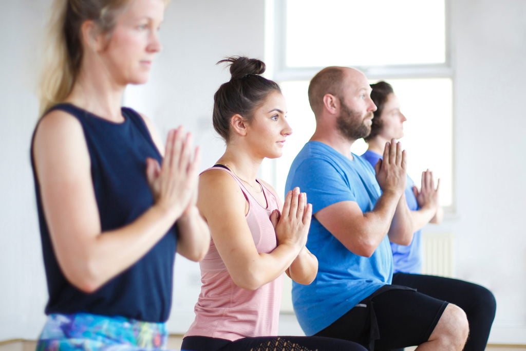 Yoga students in a kneeling lunge