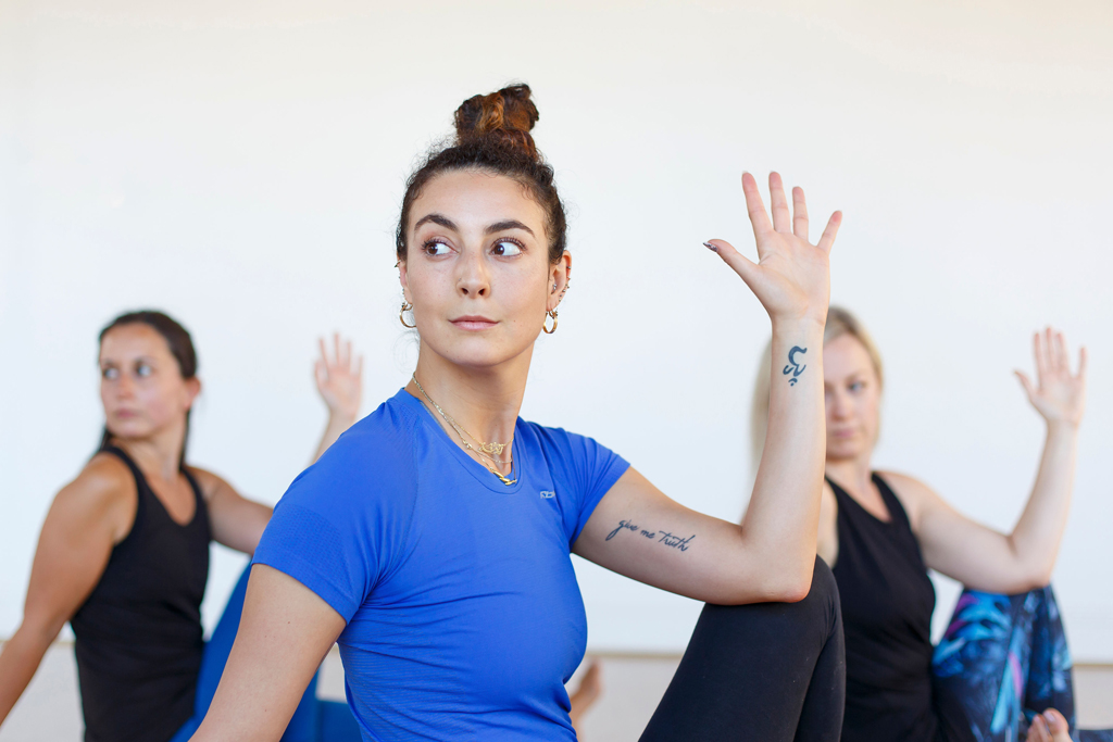 A group of ashtanga yoga students seated in a deep twist 2.